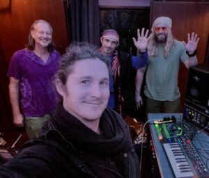 A group of people standing around a keyboard.